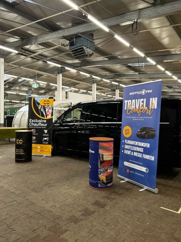 schwarzer Van von Shuttle4you bei einer Messe